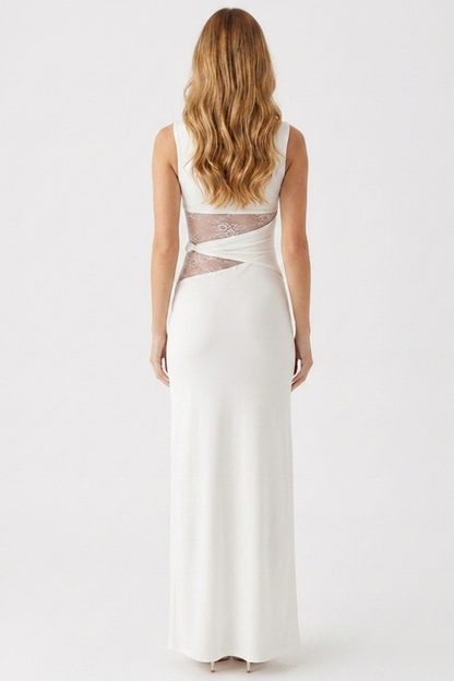 Woman wearing a white evening gown with sheer back panels on a white background